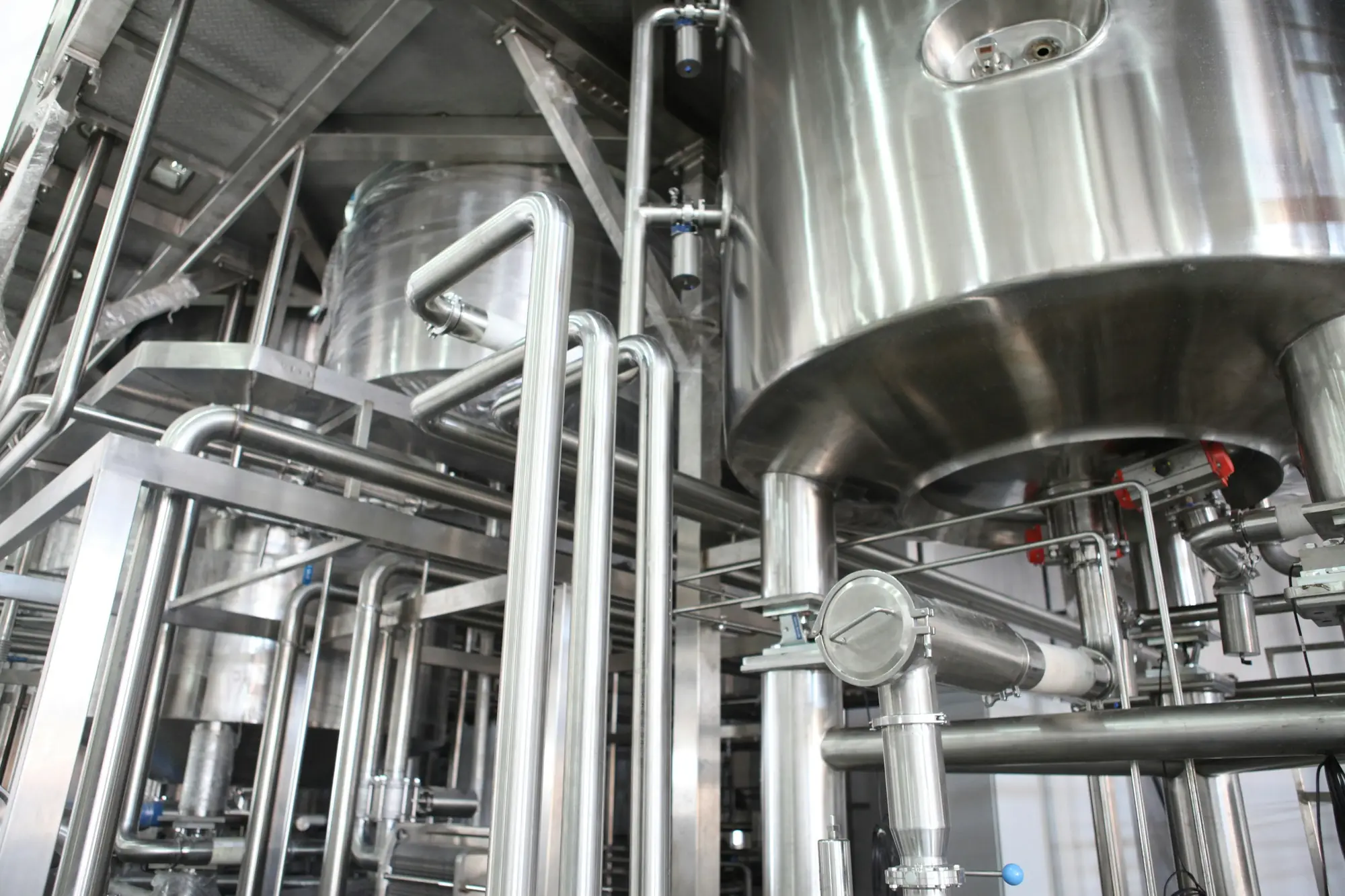 Stainless-steel process tanks, sanitary pipework and valves inside a newly installed water and chemical processing plant